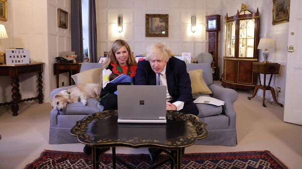 British Prime Minister Boris Johnson and his wife Carrie Johnson, with their daughter Romy, hold a video call with Doctor Laura Mount, director of Central and West Warrington, who leads a vaccination team, followed by Tom Jones, from Rickmansworth who attends RVS Rickmansworth lunch club and cares for his wife with dementia, at Chequers, the British leader's country residence near Ellesborough, Britain, December 23, 2021 - Sputnik International