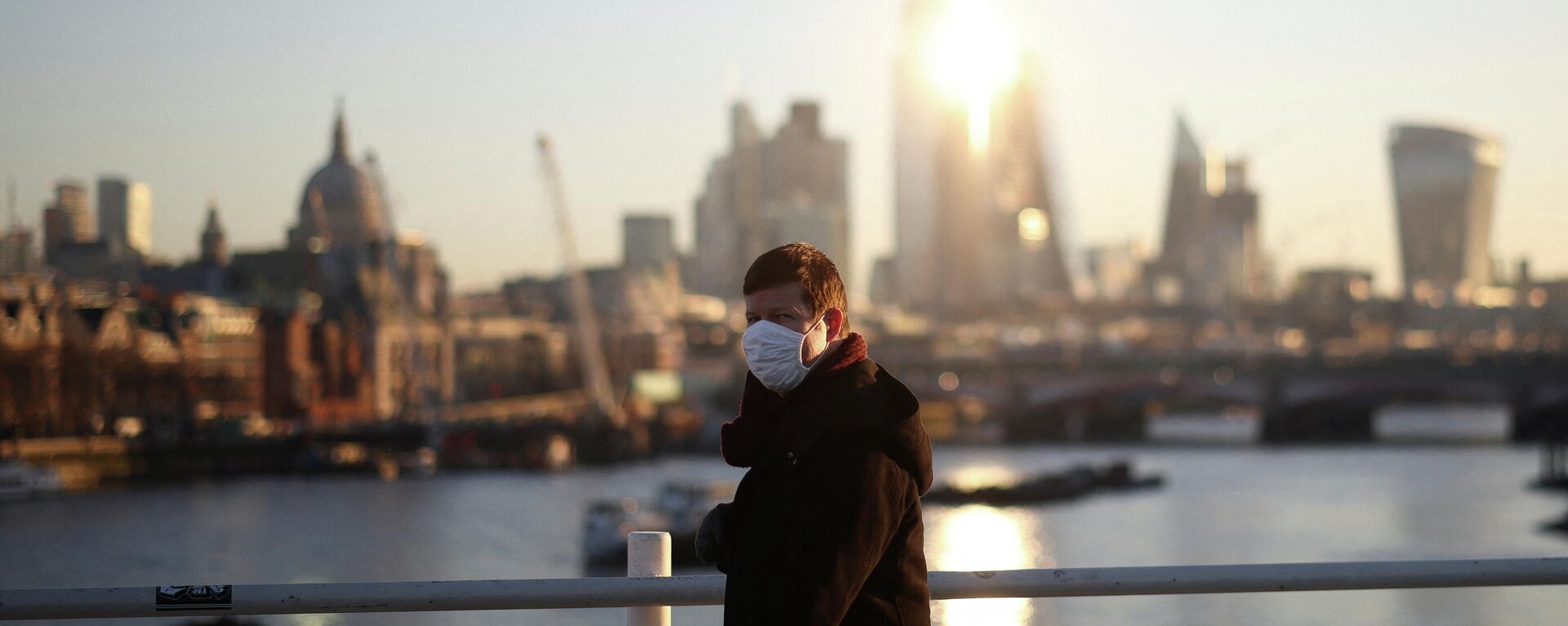 A person wearing a protective face mask walks over Waterloo Bridge during morning rush hour, amid the ongoing coronavirus disease (COVID-19) pandemic in London - Sputnik International, 1920, 21.01.2022