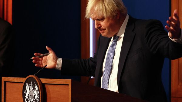 Britain's Prime Minister Boris Johnson gestures during a press conference for the latest Covid-19 update in the Downing Street briefing room in central London on December 8, 2021 - Sputnik International