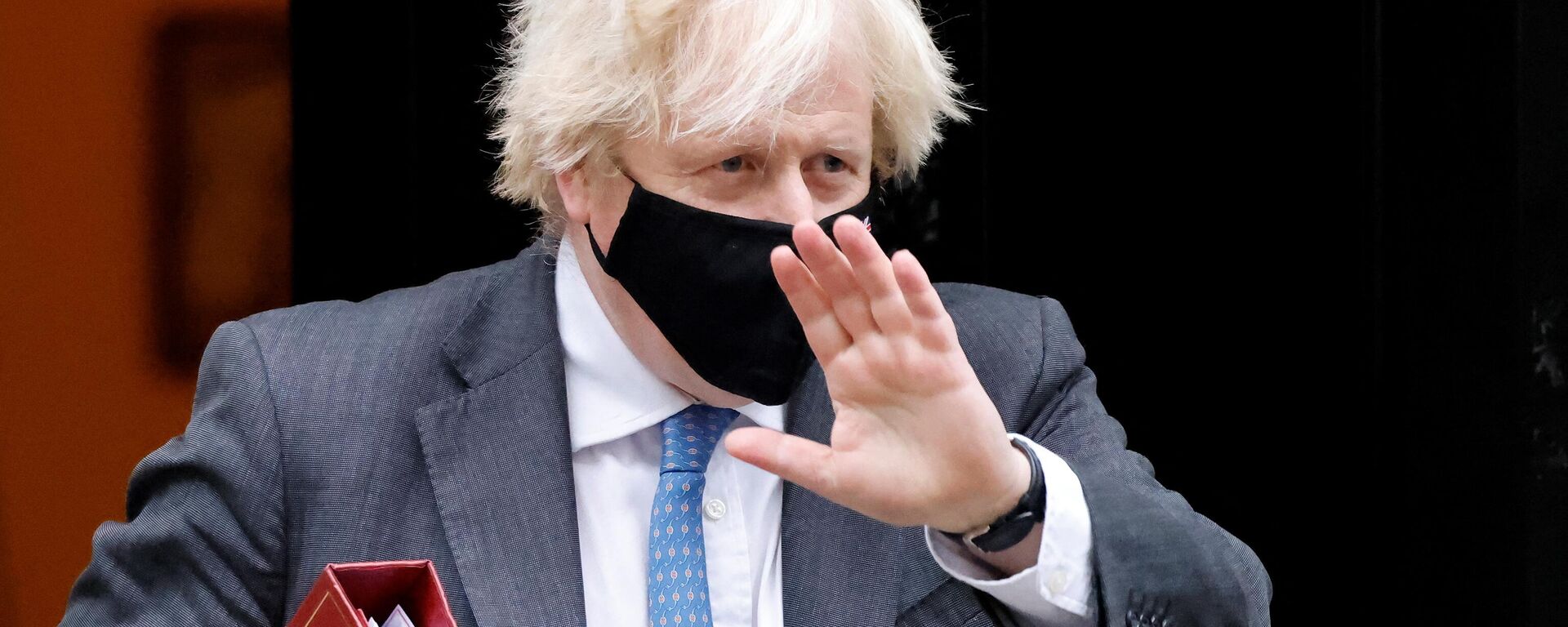 Britain's Prime Minister Boris Johnson, wearing a face covering to stop the spread of coronavirus, waves as he leaves from 10 Downing Street in central London on December 15, 2021, to take part in the weekly session of Prime Minister Questions (PMQs) at the House of Commons - Sputnik International, 1920, 27.01.2022