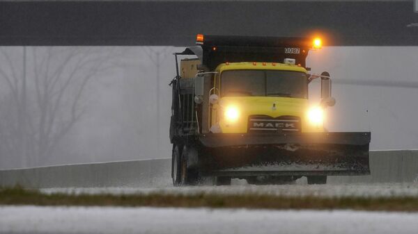 A snow plow is seen along a service road near Interstate 85 as a winter storm moves through the area near Hillsborough, N.C., Sunday, Jan. 16, 2022 - Sputnik International