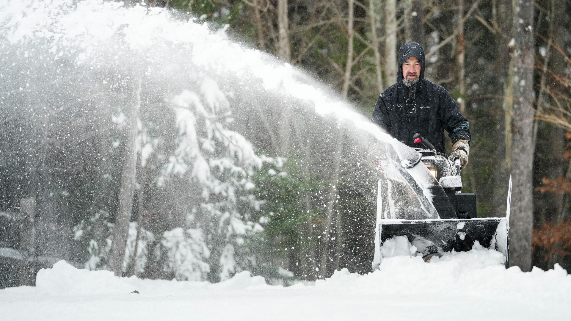 Jim Long uses his snow blower to clear a pile of snow from his driveway during a winter storm, Sunday, Jan. 16, 2022 in Morganton, N.C. A coat of ice underneath snow-covered roads made it hard to walk and clear driveways - Sputnik International, 1920, 23.01.2022