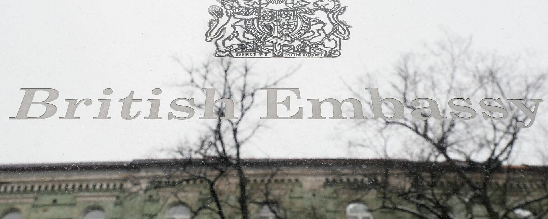 A building, which is located on the opposite side of a street, is reflected in a sign hanging on the facade of the British Embassy in Kyiv, Ukraine January 24, 2022. The British Embassy in Ukraine said some staff and dependants were being withdrawn from Kyiv amid tensions between Russia and the West over Ukraine. REUTERS/Gleb Garanich - Sputnik International, 1920, 10.02.2022