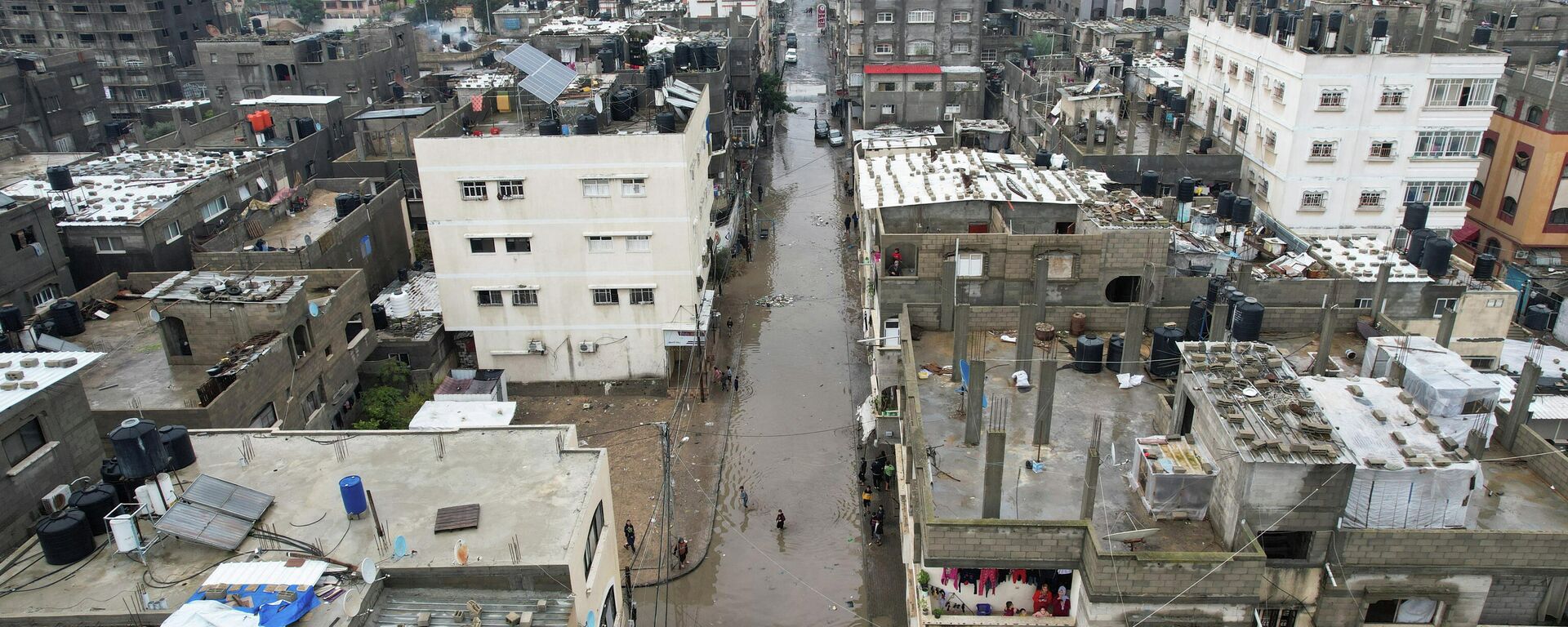 Palestinian children wade through a flooded road following heavy rains in the northern Gaza Strip, January 16, 2022. Picture taken with a drone.  - Sputnik International, 1920, 16.02.2022