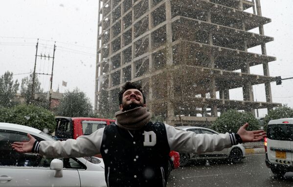 A man enjoys falling snow during a cold spell in Irbil, Iraq, Thursday, 20 January 2022. - Sputnik International