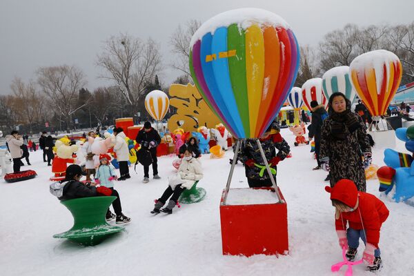 Children play in snow at an ice and snow carnival ahead of the Chinese Lunar New Year at a park in Beijing, China on 22 January 2022. - Sputnik International