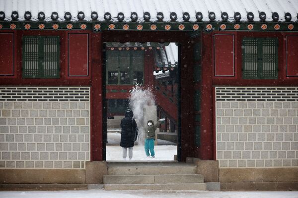 A child plays in the snow at Deoksu Palace in Seoul, South Korea, 19 January 2022. - Sputnik International