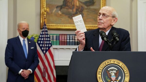 U.S. Supreme Court Justice Stephen Breyer holds up a copy of the U.S. Constitution, while President Joe Biden looks on, as Breyer announces he will retire at the end of the court's current term, at the White House in Washington, U.S. - Sputnik International