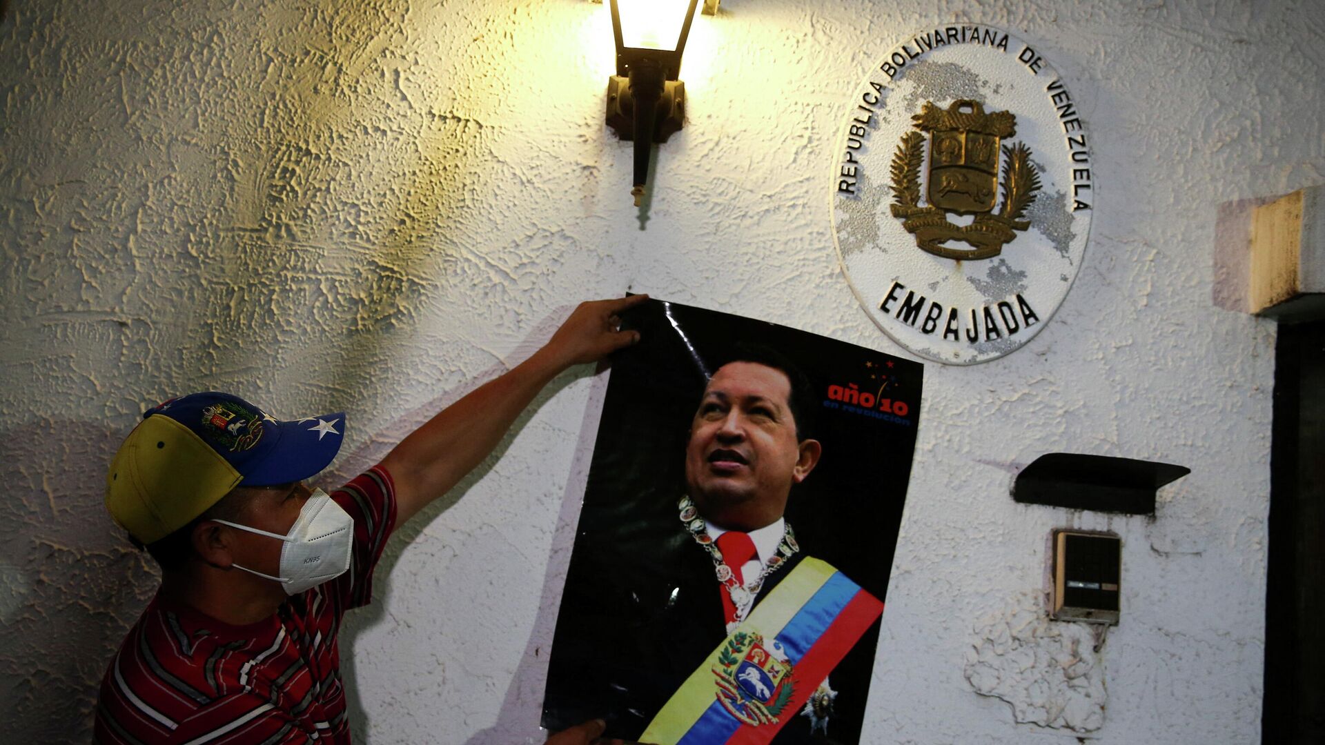 A former employee displays a picture of late former Venezuelan president Hugo Chavez as activists participate in the recovery of the Venezuelan embassy, which had been closed since 2009, in Tegucigalpa, Honduras January 27, 2022.  - Sputnik International, 1920, 28.01.2022