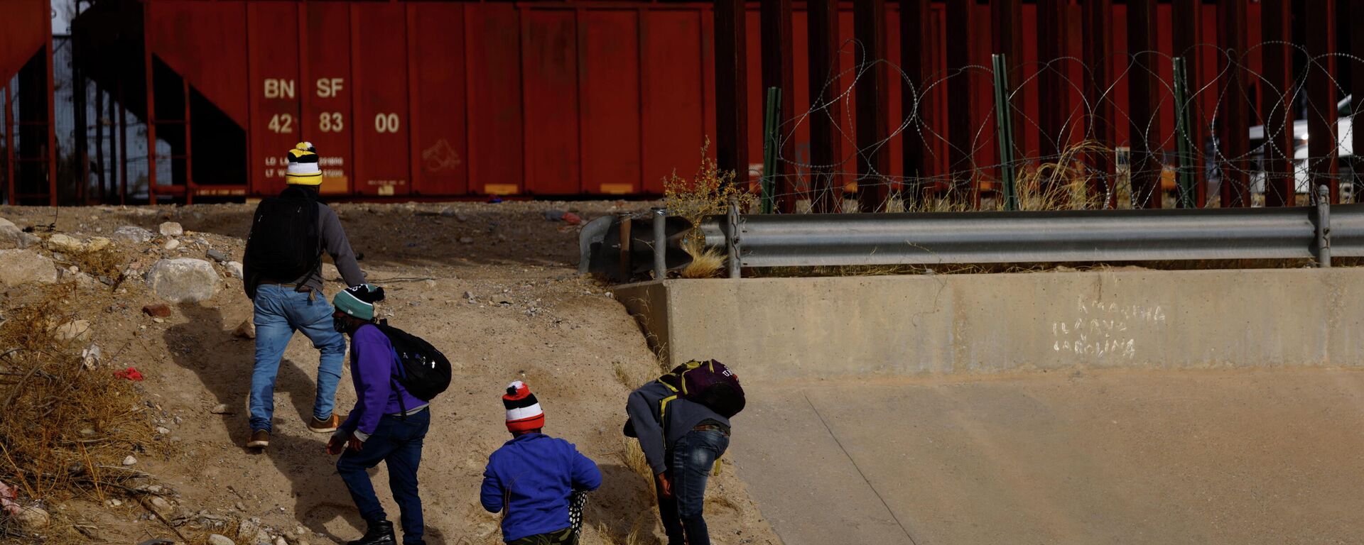 Asylum-seeking migrants from Haiti walk near the border wall after crossing the Rio Bravo river to turn themselves in to U.S. Border Patrol agents to request asylum in El Paso, Texas, U.S., as seen from Ciudad Juarez, Mexico January 03, 2022.  - Sputnik International, 1920, 30.01.2022