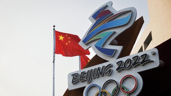 The Chinese national flag flies behind the logo of the Beijing 2022 Winter Olympics in Beijing, China, January 14, 2022 - Sputnik International