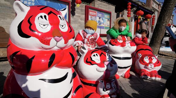 Children wearing masks pose for photos near Tiger sculptures on the first day of the Chinese Lunar Year of the Tiger in Beijing, China,  - Sputnik International