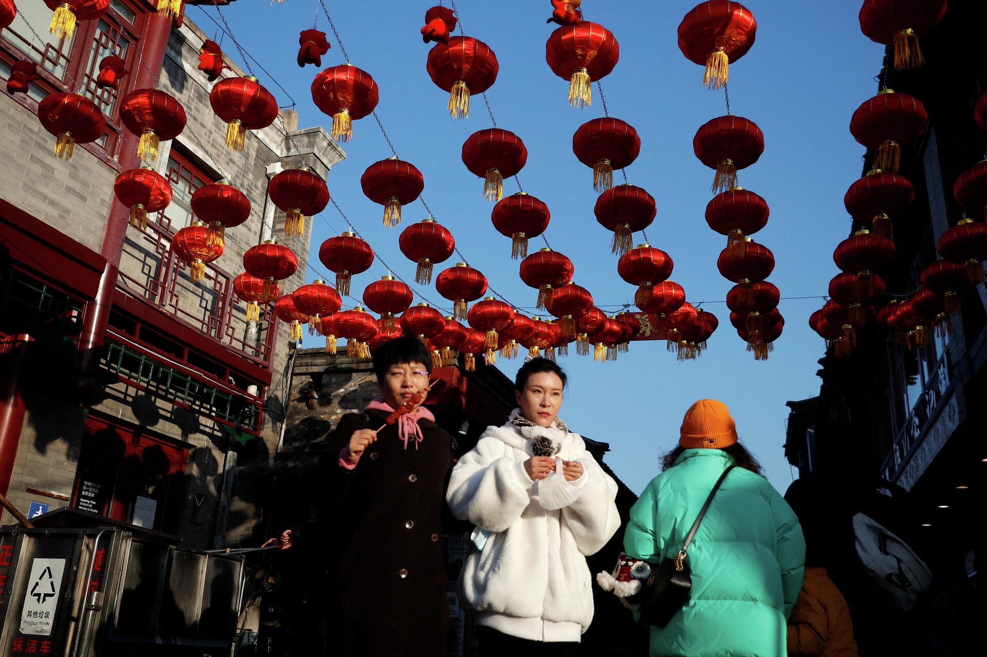 People walk at a hutong alley decorated with lanterns ahead of the Chinese Lunar New Year, in Beijing, China January 29, 2022. - Sputnik International, 1920, 02.02.2022