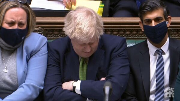 A video grab from footage broadcast by the UK Parliament's Parliamentary Recording Unit (PRU) shows British Prime Minister Boris Johnson reacting as Britain's main opposition Labour Party leader Keir Starmer (unseen) speaks during Prime Minister's Questions (PMQs), in the House of Commons in London on January 19, 2022 - Sputnik International