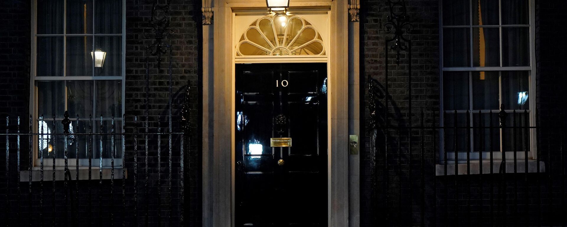 A light shines above the door of 10 Downing Street, the official residence of Britain's Prime Minister, in central London on January 31, 2022. - Sputnik International, 1920, 04.02.2022