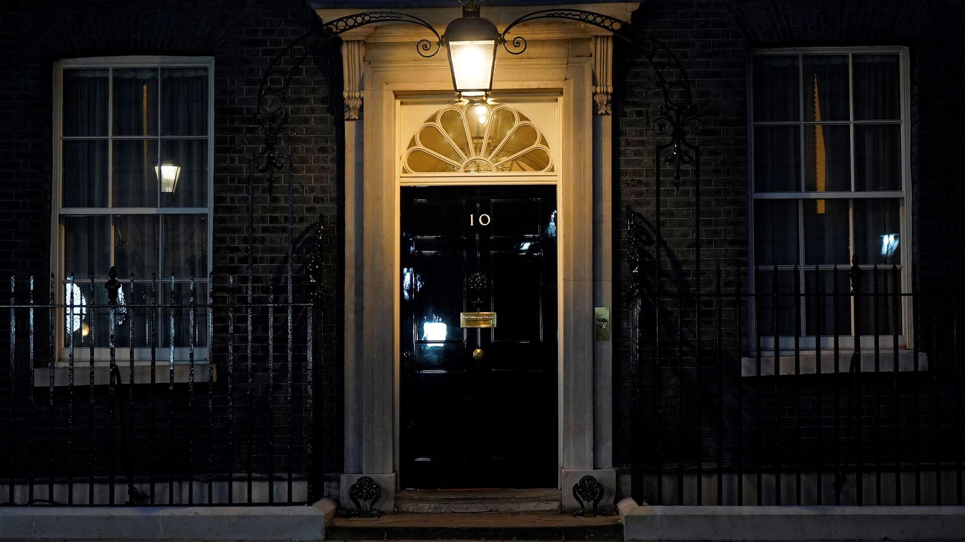 A light shines above the door of 10 Downing Street, the official residence of Britain's Prime Minister, in central London on January 31, 2022. - Sputnik International, 1920, 10.02.2022