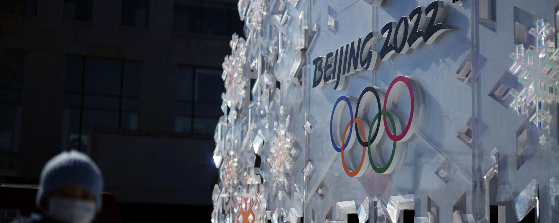 A person stands near a Beijing 2022 installation outside the closed-loop bubble, before the opening ceremony of the Beijing 2022 Winter Olympics in Beijing - Sputnik International, 1920, 04.02.2022