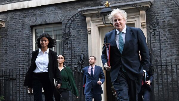 In this file photo taken on December 15, 2020 Britain's Prime Minister Boris Johnson (R) leaves 10 Downing Street in London with Director of the Number 10 Policy Unit Munira Mirza (L) to attend the weekly cabinet meeting held at the nearby Foreign, Commonwealth and Development Office. - Sputnik International