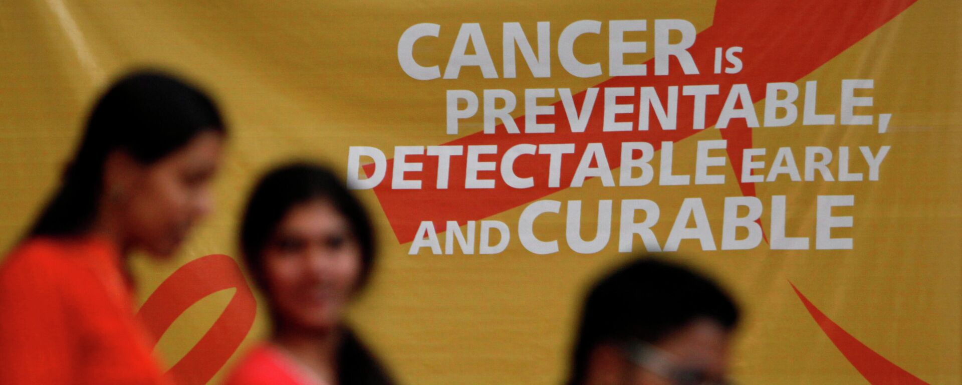 A flash mob participants walk in front of a hoarding spreading awareness on cancer in Hyderabad, India, Friday, Feb. 3, 2012. World Cancer Day will be marked on Feb. 4. - Sputnik International, 1920, 04.02.2022