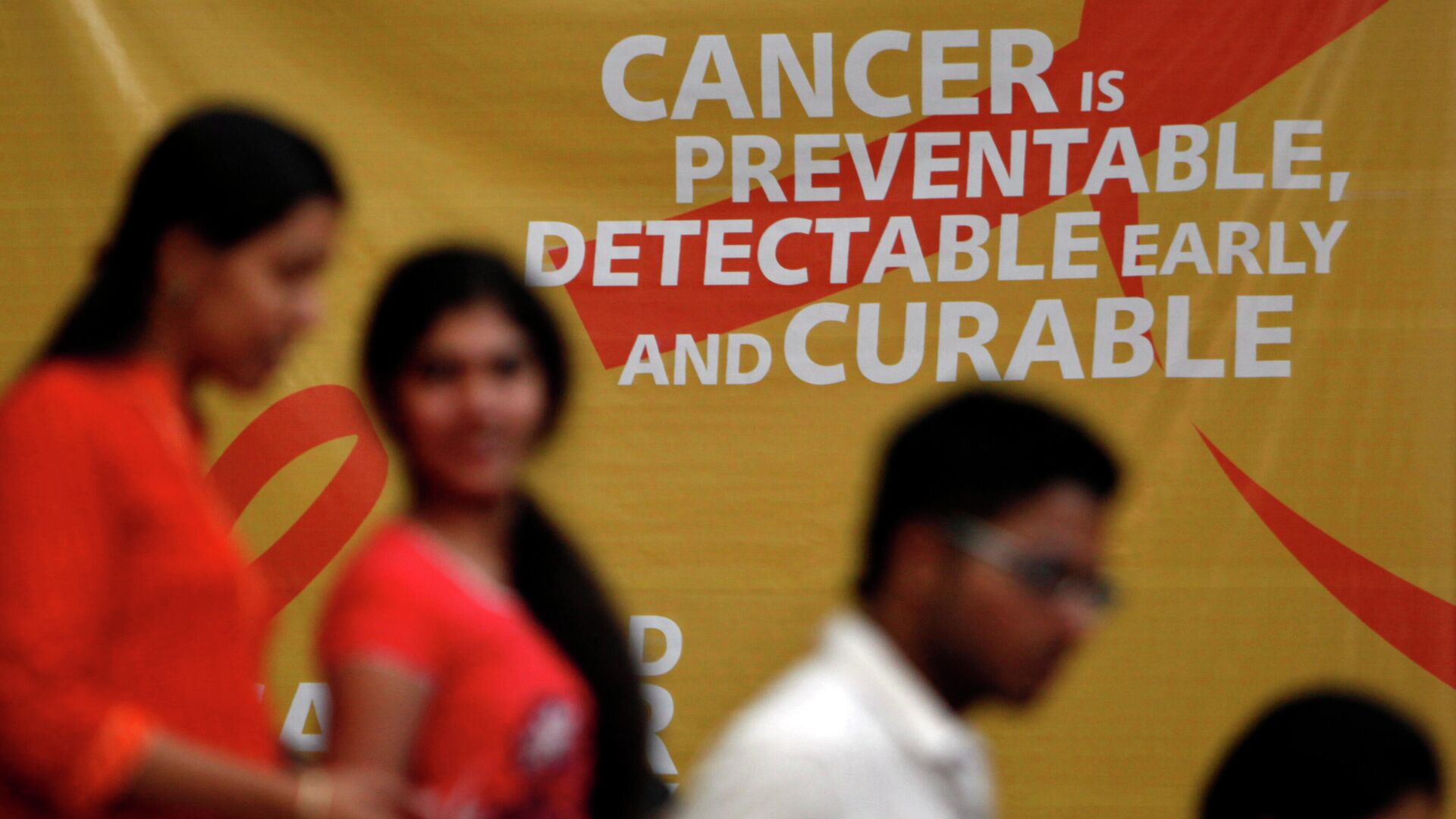 A flash mob participants walk in front of a hoarding spreading awareness on cancer in Hyderabad, India, Friday, Feb. 3, 2012. World Cancer Day will be marked on Feb. 4. - Sputnik International, 1920, 04.02.2022