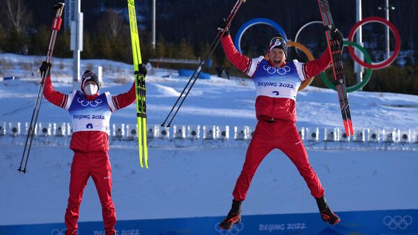 Silver medalist Russian Olympic Committee's Denis Spitsov and gold medalist Russian Olympic Committee's Alexander Bolshunov celebrate on the podium  - Sputnik International