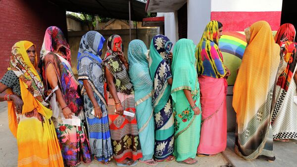 Rural Hindu women with their faces covered stand in a queue to cast their votes at a polling station on the outskirts of Prayagraj, Uttar Pradesh state, India, Sunday, May 12, 2019 - Sputnik International