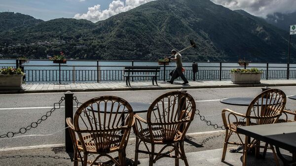 A workers walks holding a lawn mowers in Tremezzo, Lake Como, Italy, Thursday, May 14, 2020. Regional governors have been pressing the government to be permitted to present their own reopening plans, taking into account the level of infection and also the growing economic crisis.  - Sputnik International