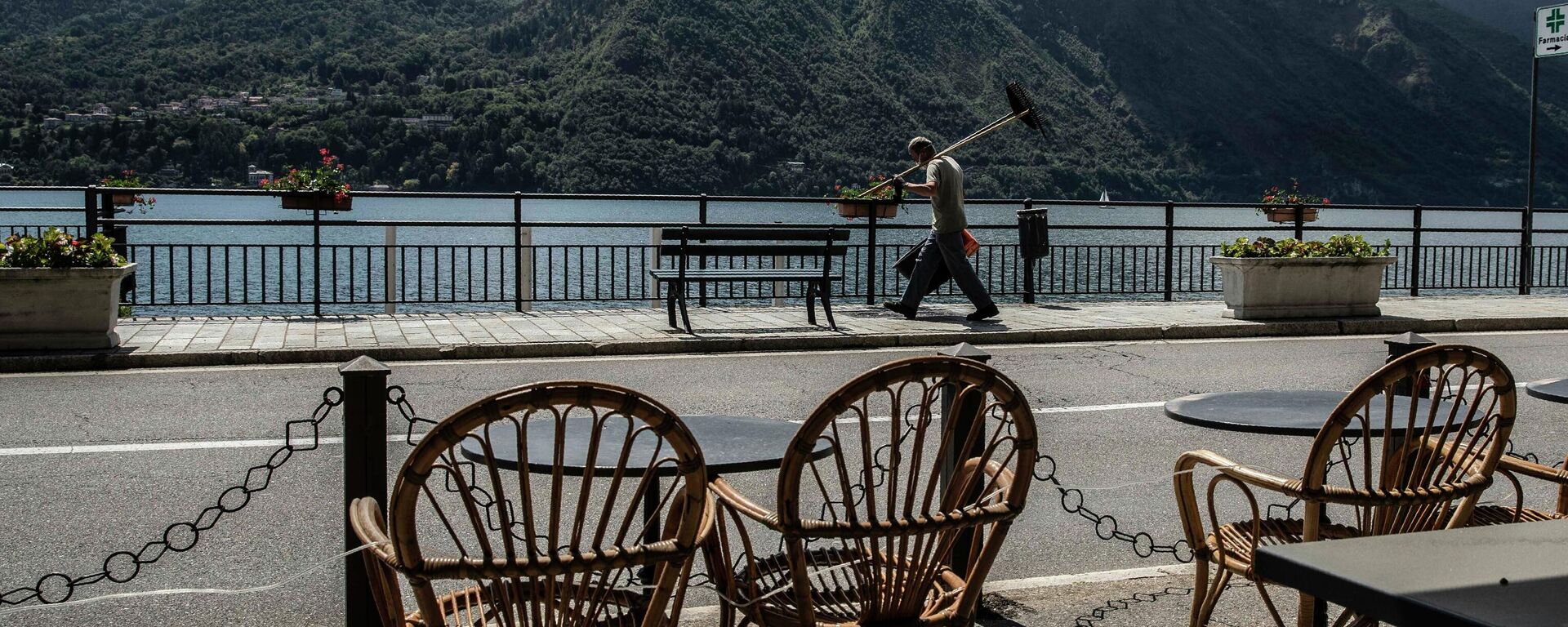 A workers walks holding a lawn mowers in Tremezzo, Lake Como, Italy, Thursday, May 14, 2020. Regional governors have been pressing the government to be permitted to present their own reopening plans, taking into account the level of infection and also the growing economic crisis.  - Sputnik International, 1920, 11.10.2022