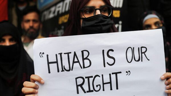 A Muslim woman holds a placard as she takes part in a protest organised by All India Majlis-e-Ittehadul Muslimeen (AIMM) against the recent hijab ban in few colleges of Karnataka state, at Shaheen Bagh in New Delhi, India, February 9, 2022 - Sputnik International