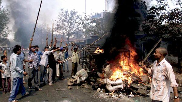Youths burn vehicles and debris in the streets of Ahmadabad, in the Indian state of Gujarat, Thursday, Feb. 28, 2002, a day after a Muslim mob attacked a train, killing at least 58 people - Sputnik International