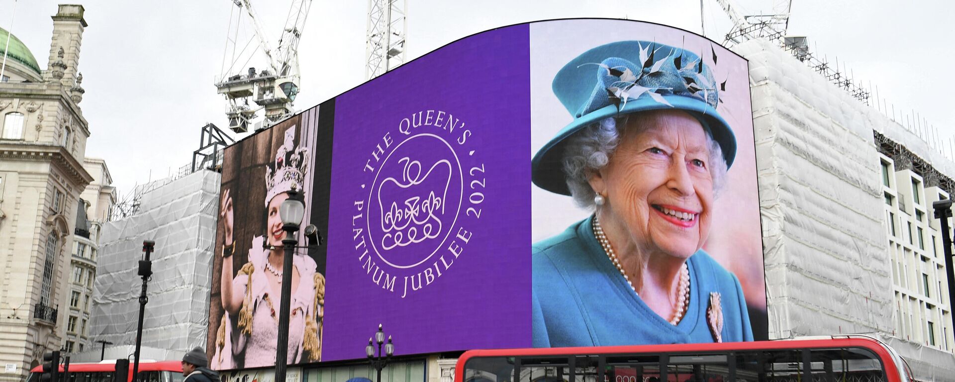 Red London buses pass by, as images of Britain's Queen Elizabeth II are displayed on the big digital screens at Piccadilly Circus in central London on February 6, 2022, to mark the start of Her Majesty's Platinum Jubilee Year - Sputnik International, 1920, 23.02.2022