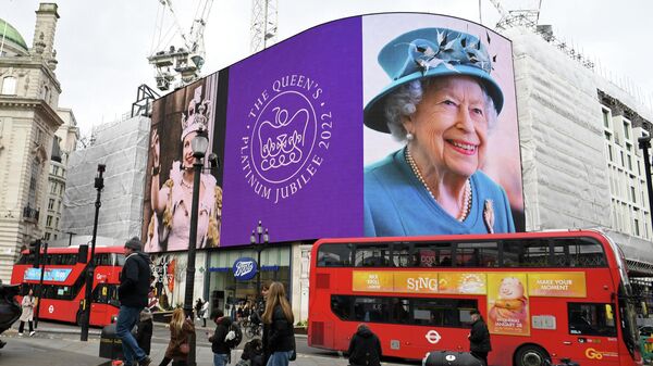 Red London buses pass by, as images of Britain's Queen Elizabeth II are displayed on the big digital screens at Piccadilly Circus in central London on February 6, 2022, to mark the start of Her Majesty's Platinum Jubilee Year - Sputnik International