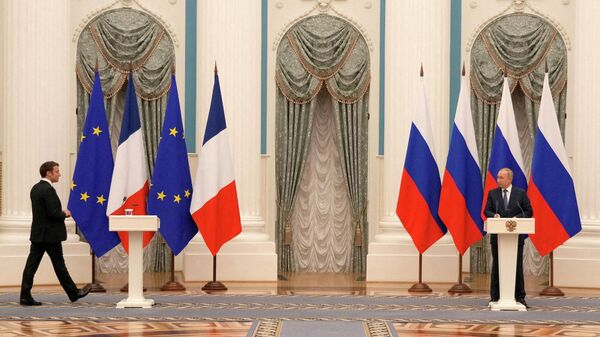 FILE PHOTO: Russian President Vladimir Putin watches French President Emmanuel Macron arriving for a press conference after their talks, in Moscow, Russia, February 7, 2022 - Sputnik International