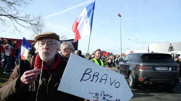 A protester holds a placard reading Congratulations, Paris, Brussels as a so-called Freedom Convoy (Convoi de la Liberte) passes through Le Mans, western France, on February 11, 2022. - Sputnik International