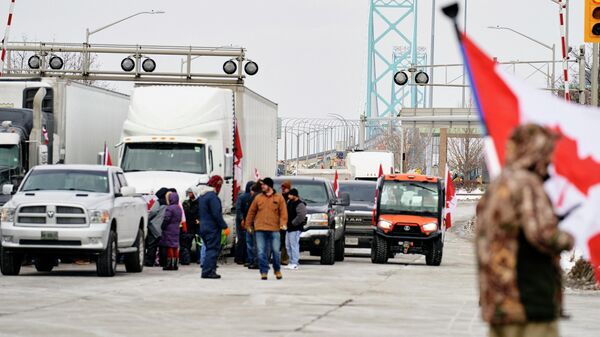 Supporters of the Truckers Convoy against the Covid-19 vaccine mandate block traffic in Canada bound lanes of the Ambassador Bridge border crossing, in Windsor, Ontario, on February 8, 2022. - Sputnik International