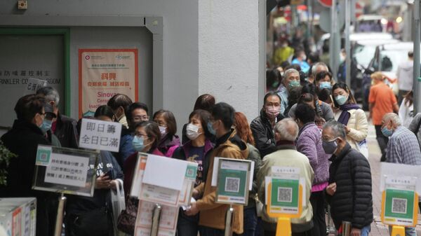 People wearing face masks queue outside a community vaccination centre to receive a dose of Sinovac Biotech's CoronaVac COVID-19 vaccine, in Hong Kong, China February 10, 2022. - Sputnik International