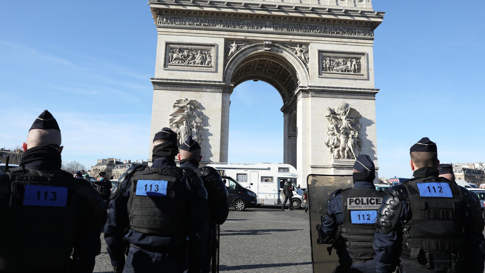 A camper van part of a convoy drives past the Arc de Triomphe on the Champs-Elysees avenue as police officers stand guard, Saturday, Feb.12, 2022 in Paris. Paris police intercepted at least 500 vehicles attempting to enter the French capital in defiance of a police order to take part in protests against virus restrictions inspired by the Canada's horn-honking Freedom Convoy.  - Sputnik International, 1920, 02.07.2023