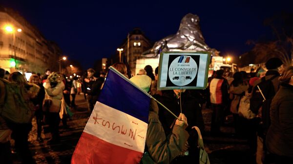 Protesters hold a French flag and a sign reading 'I support the freedom convoy' at Place Denfert-Rochereau in southern Paris on February 11, 2022. - Sputnik International