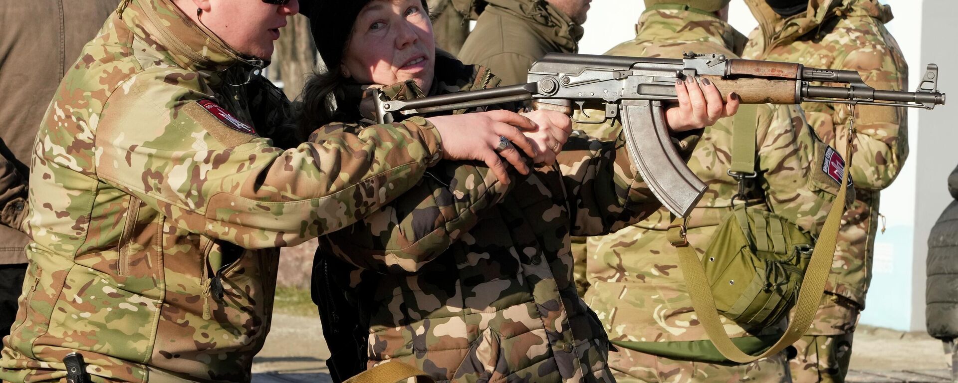 An instructor shows a woman how to use a Kalashnikov assault rifle, as members of a Ukrainian far-right group train, in Kyiv, Ukraine, Sunday, Feb. 13, 2022. Russia denies it intends to invade but has massed well over 100,000 troops near the Ukrainian border and has sent troops to exercises in neighboring Belarus, encircling Ukraine on three sides. U.S. officials say Russia's buildup of firepower has reached the point where it could invade on short notice. - Sputnik International, 1920, 25.11.2022