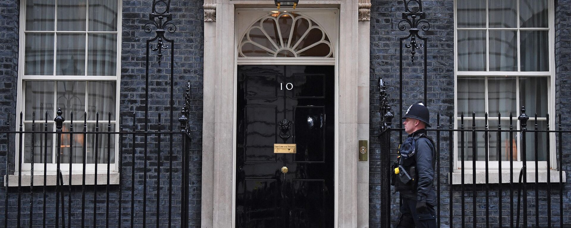 A police officer walks past the door to 10 Downing Street, the official residence of Britain's Prime Minister, in London on January 25, 2022 - Sputnik International, 1920, 20.02.2022