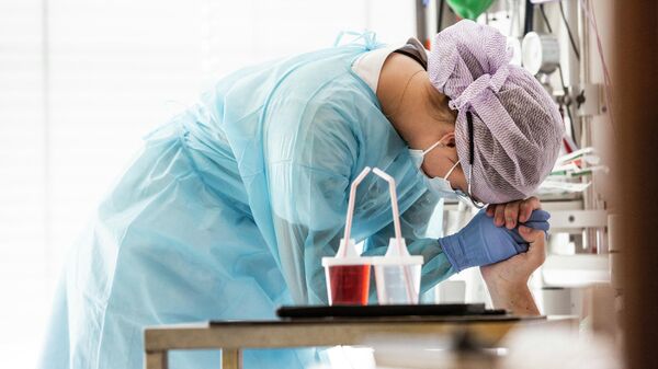 A nurse comforts a patient with the Covid-19 disease who just woke up from unconsciousness after being operated at Herlev Hospital's Department of Anesthesia, Operation and Intensive Care, in Copenhagen, Denmark, at the beginning of May 2020 - Sputnik International