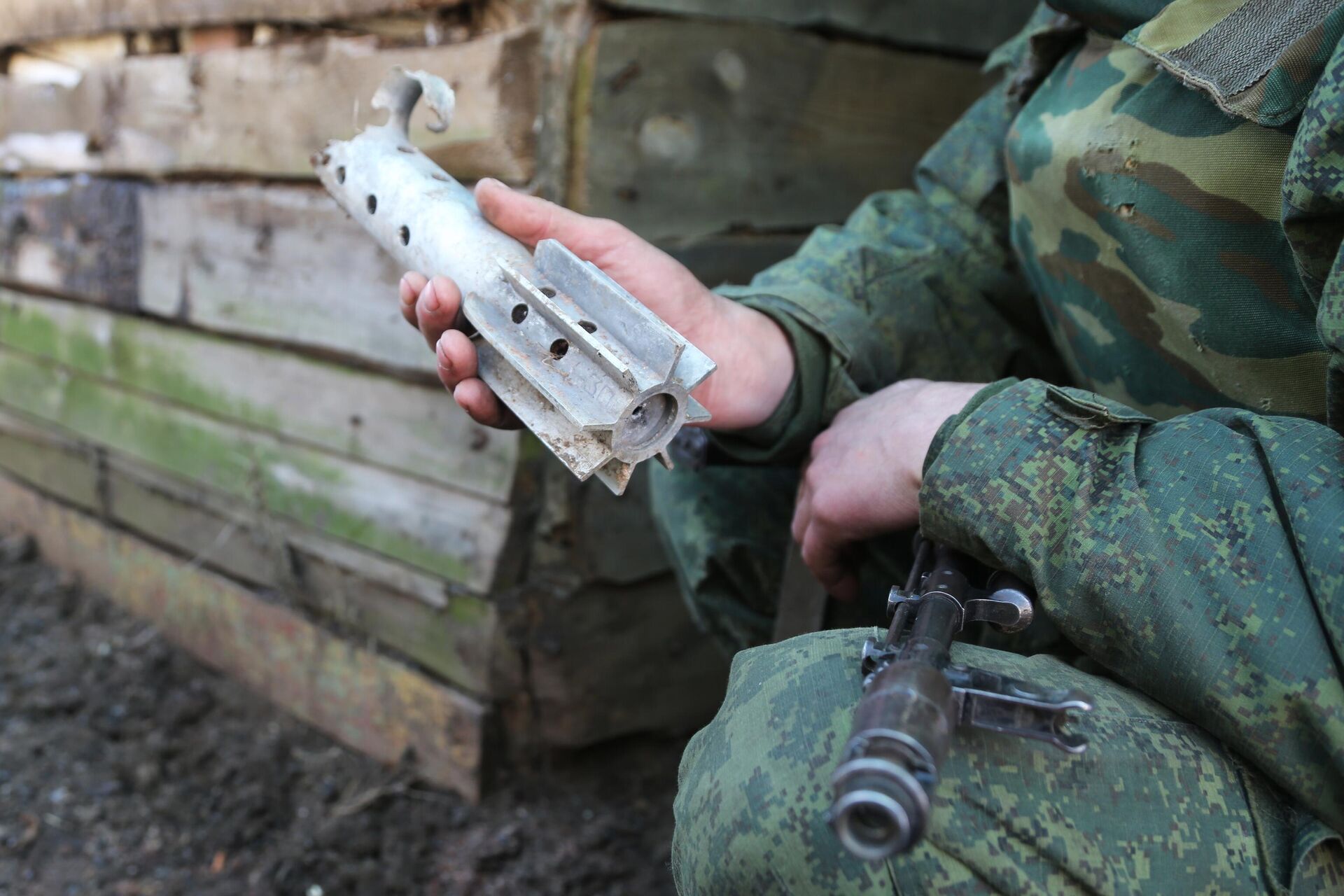 Donbass militiaman holds up piece of shell fired on his comrades' position by Kiev forces in Western Donetsk. 15 February 2022. - Sputnik International, 1920, 21.02.2022