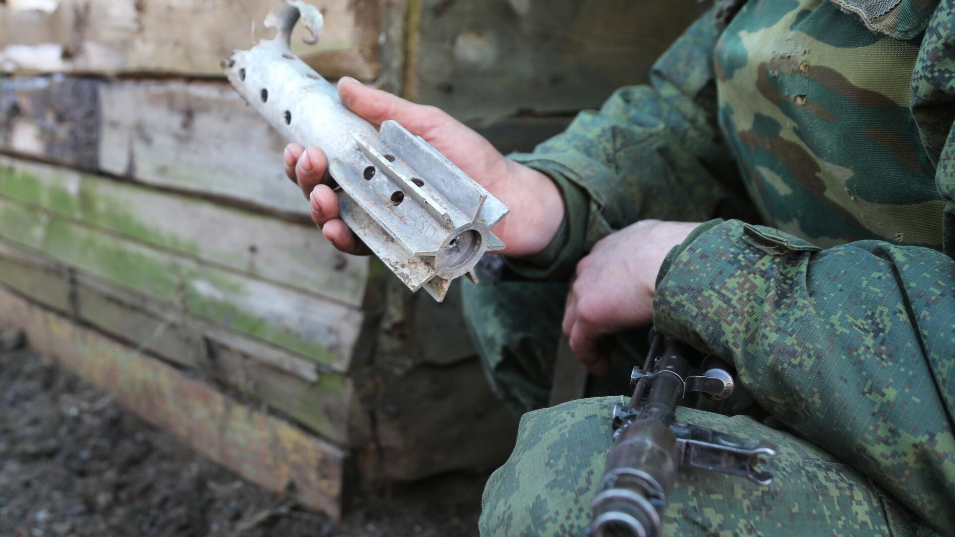 Donbass militiaman holds up piece of shell fired on his comrades' position by Kiev forces in Western Donetsk. 15 February 2022. - Sputnik International, 1920, 24.02.2022