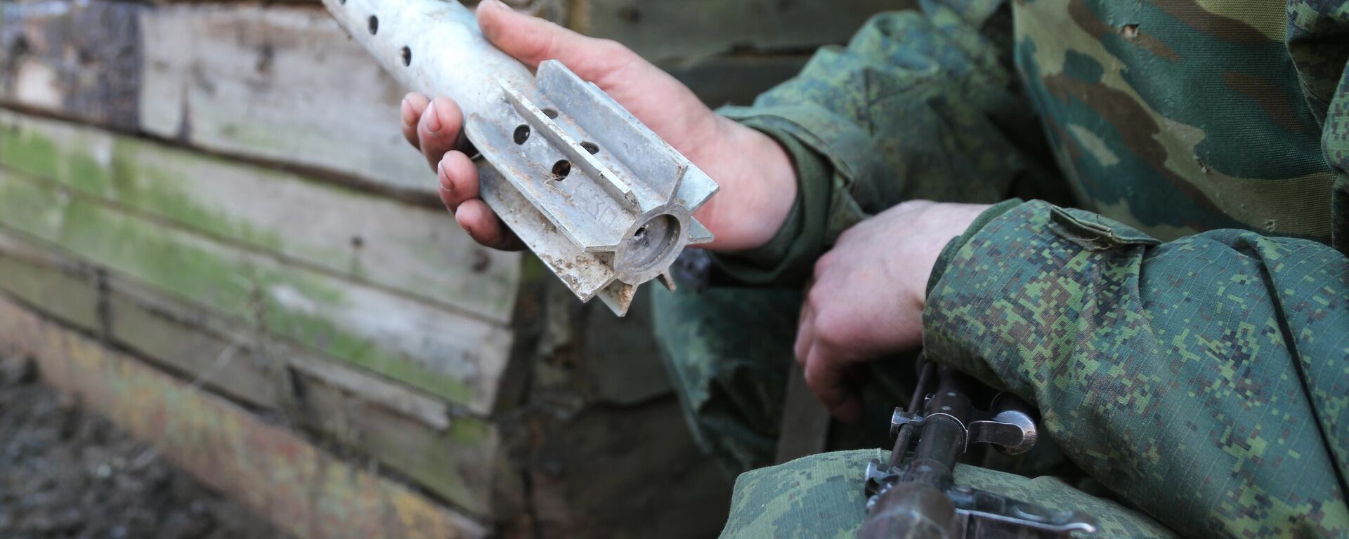 Donbass militiaman holds up piece of shell fired on his comrades' position by Kiev forces in Western Donetsk. 15 February 2022. - Sputnik International, 1920, 22.02.2022