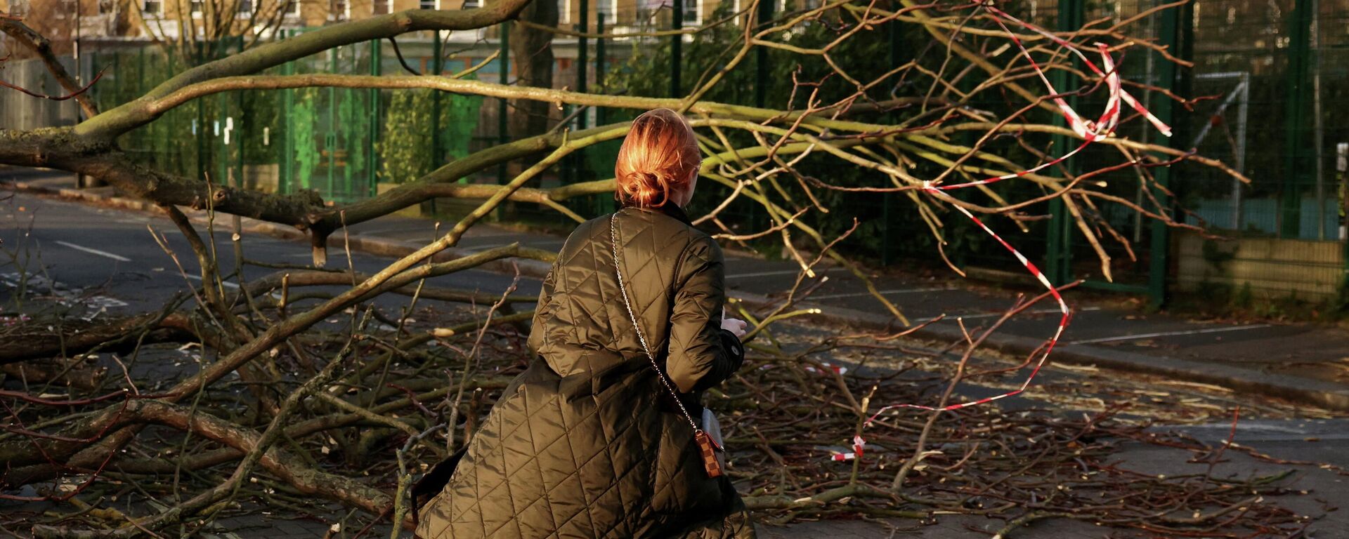 A woman walks past a fallen tree on a side street in Fulham during Storm Eunice, in London - Sputnik International, 1920, 19.02.2022