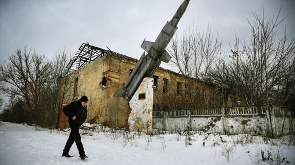 A man walks past a destroyed building of a former military installation in the village of Vesyoloye, suburb of Donetsk, capital of a self-proclaimed Donetsk People's Republic (DPR) in eastern Ukraine - Sputnik International