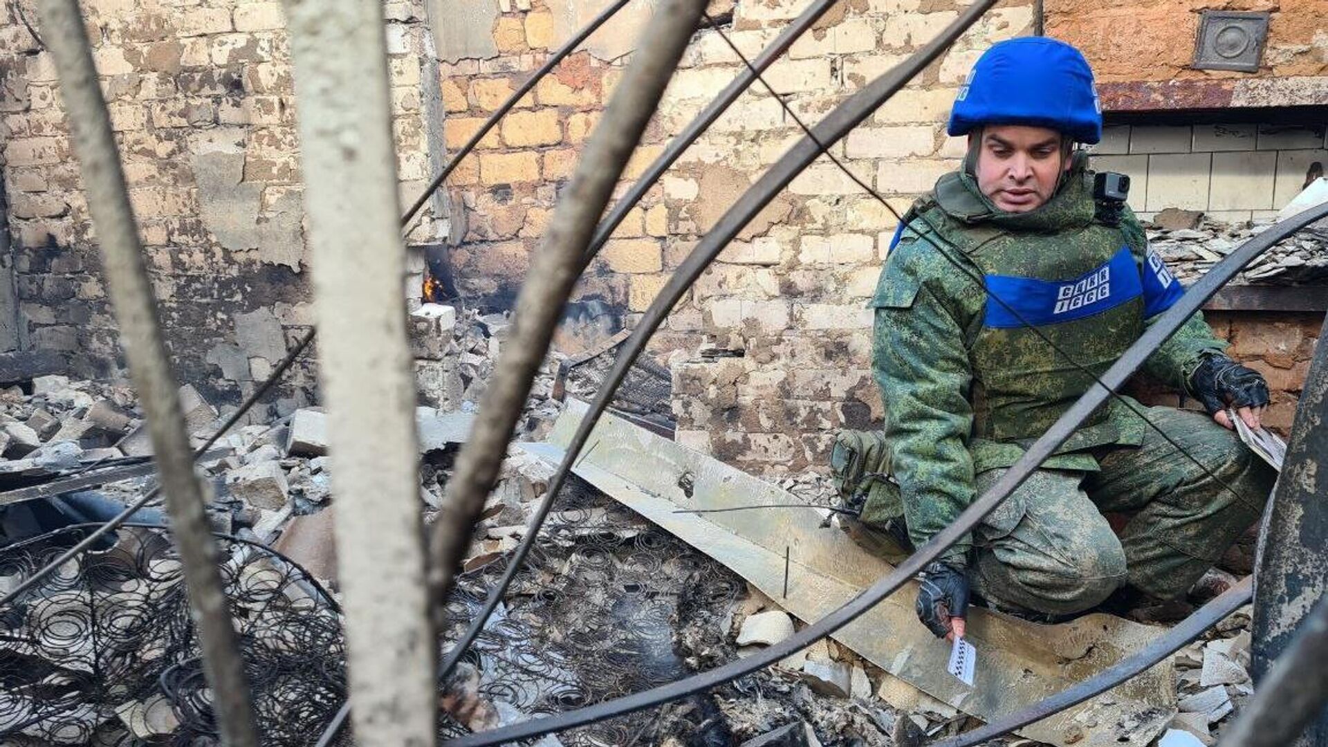 A representative of the Joint Centre for Control and Coordination of the Ceasefire Regime (JCCC) of the LPR near the house that was hit by an artillery strike by the Ukrainian Armed Forces on the village of Pionerskoye in the LPR. - Sputnik International, 1920, 27.02.2022
