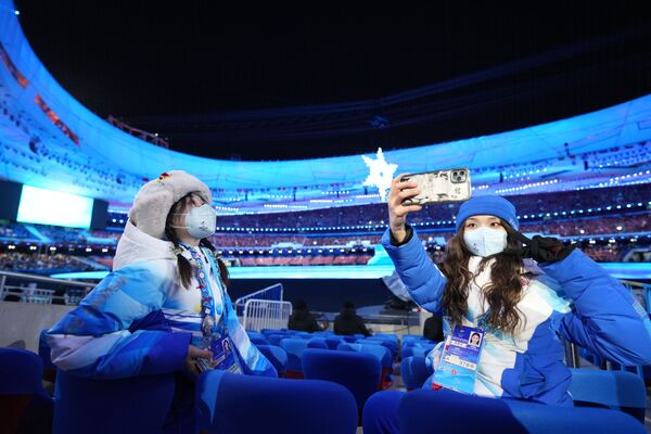 Volunteers take pictures at the National Stadium in Beijing prior to the beginning of the closing ceremony of the 2022 Winter Olympics. - Sputnik International