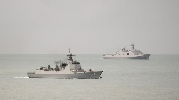 A handout photo taken on February 18, 2022 and received on February 20, 2022 shows a Chinese  PLA-N Luyang-class guided missile destroyer (L) and a PLA-N Yuzhao-class amphibious transport dock vessel (R) leaving the Torres Strait and entering the Coral Sea after the Australian Defence Force confirm that on 17 February 2022, a Royal Australian Air Force (RAAF) P-8A Poseidon detected a laser illuminating the aircraft from a People’s Liberation Army – Navy (PLA-N) vessel - Sputnik International