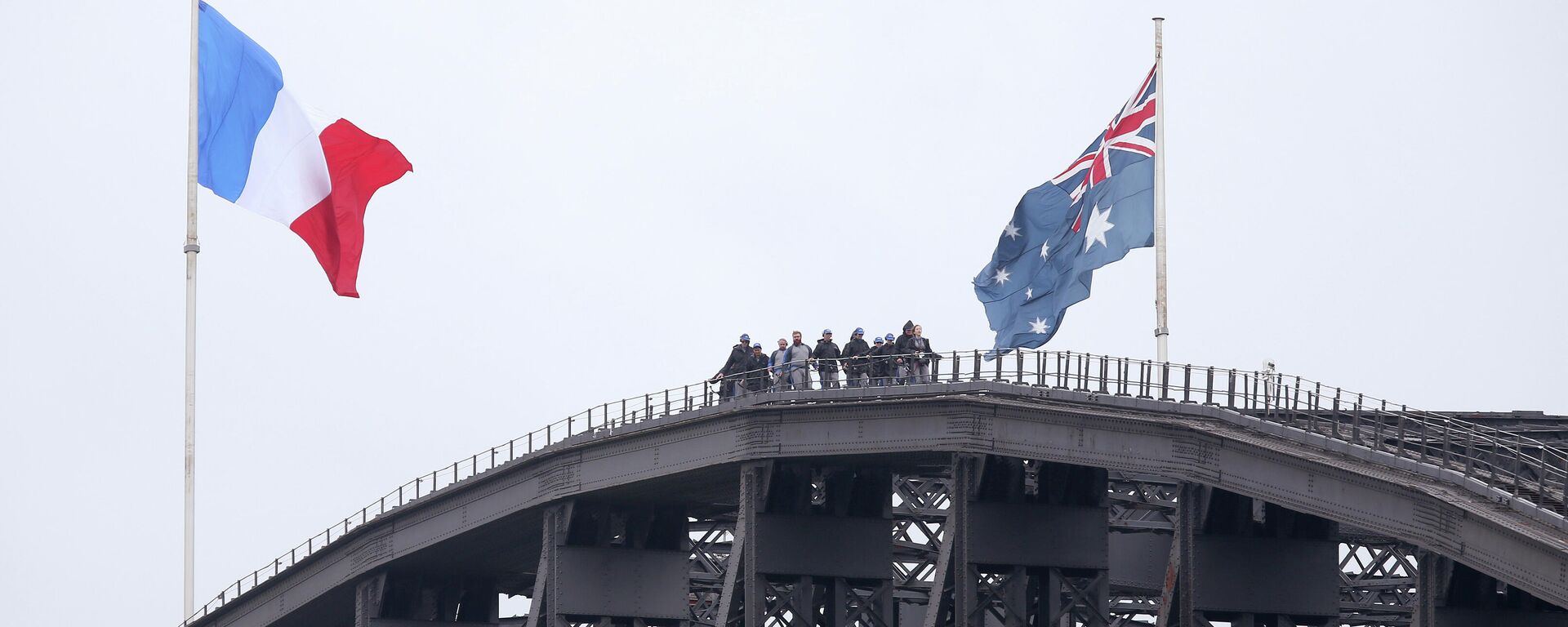 People walk along the top of the Sydney Harbour Bridge where a French flag, left, is flying alongside an Australian flag in Sydney, Sunday, Nov. 15, 2015 - Sputnik International, 1920, 22.02.2022